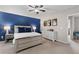 Inviting bedroom featuring a striking blue accent wall, complemented by stylish furniture, creating a tranquil retreat at 6407 Barker Station Walk, Sugar Hill, GA 30518