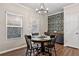 Charming dining area featuring a round wooden table, dark wood chairs, and decorative floral wallpaper at 6407 Barker Station Walk, Sugar Hill, GA 30518