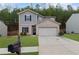 Charming two-story home featuring a brick facade, a well-manicured lawn, and an attached two-car garage at 6407 Barker Station Walk, Sugar Hill, GA 30518