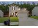 Charming two-story home featuring a brick facade, a well-manicured lawn, and an attached two-car garage at 6407 Barker Station Walk, Sugar Hill, GA 30518
