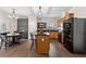 Bright kitchen with wooden cabinets, granite countertops, black appliances, and an adjacent dining area at 6407 Barker Station Walk, Sugar Hill, GA 30518