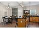 Spacious kitchen with wooden cabinets, granite countertops, modern lighting, and adjacent dining area with floral wallpaper at 6407 Barker Station Walk, Sugar Hill, GA 30518