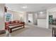 Spacious living room with neutral walls, floral sofa, and open access to other areas of the home at 6407 Barker Station Walk, Sugar Hill, GA 30518