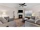 Comfortable living room with a fireplace, ceiling fan, and neutral tones, perfect for relaxation and gatherings at 6407 Barker Station Walk, Sugar Hill, GA 30518