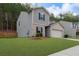 Charming two-story home with a manicured lawn and a two-car garage, set against a backdrop of lush greenery at 6407 Barker Station Walk, Sugar Hill, GA 30518