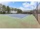 Well-maintained community tennis court with green and blue surface, surrounded by a tall fence and trees at 6407 Barker Station Walk, Sugar Hill, GA 30518