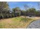 Grassy backyard featuring a wooden fence, landscaping, and a gravel fire pit area at 1611 Flat Shoals Rd, Atlanta, GA 30316