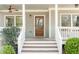 Close-up of the front porch with wood door, white railings, and manicured bushes at 1611 Flat Shoals Rd, Atlanta, GA 30316