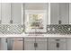 Close up on stainless steel sink, modern backsplash and white countertop in remodeled kitchen at 1611 Flat Shoals Rd, Atlanta, GA 30316
