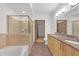 Modern bathroom with double sinks, granite countertops, and a glass-enclosed shower and soaking tub at 390 17Th Nw St # 4048, Atlanta, GA 30363