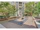 Landscaped courtyard with sculpture, brick pavers, seating areas, and lush trees offering a community gathering space at 390 17Th Nw St # 4048, Atlanta, GA 30363