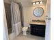 Bathroom with a shower, toilet, vanity with granite countertop, black cabinet, and round mirror at 430 Holly Stream Trl, Roswell, GA 30075