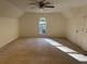 Spacious bedroom with neutral carpet, ceiling fan, and natural light from the window at 430 Holly Stream Trl, Roswell, GA 30075