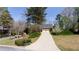 Long driveway leading to a two-car garage, surrounded by mature trees and well-manicured landscaping at 430 Holly Stream Trl, Roswell, GA 30075