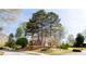 Beautiful brick home nestled among mature trees, showcasing its classic architecture and well-maintained landscaping at 430 Holly Stream Trl, Roswell, GA 30075