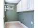 This functional laundry room features upper cabinets for storage and a clean, well-maintained appearance at 430 Holly Stream Trl, Roswell, GA 30075