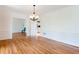 Living room featuring wood floors, a chandelier, and white walls with decorative molding at 430 Holly Stream Trl, Roswell, GA 30075