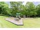 Community playground with climbing rock, swings, slides, picnic tables, and mature trees for a shady play area at 430 Holly Stream Trl, Roswell, GA 30075
