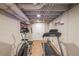Basement work-out room features two work-out machines on a laminate floor, white cinder block walls, and white door at 4537 Ashmore Cir, Marietta, GA 30066