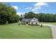 Exterior of a lovely home at dusk, surrounded by trees and lush green lawn at 340 Taylor Path, Dallas, GA 30157
