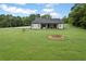 Spacious backyard features ample lawn space with a fire pit and tree line at 340 Taylor Path, Dallas, GA 30157