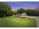 Exterior of a lovely home at dusk, surrounded by trees and lush green lawn at 340 Taylor Path, Dallas, GA 30157