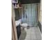 Compact bathroom with tiled floors, black vanity, and patterned shower curtain at 3905 Hunters Chase, Conyers, GA 30094