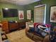 Cozy bedroom featuring green walls, a large TV, comfortable seating, and unique decor at 3905 Hunters Chase, Conyers, GA 30094