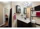 Bathroom with dark vanity, sink, decorative mirror, towels, and doorway to the shower/laundry area at 1501 Eastern Sunrise Ln, Decatur, GA 30034