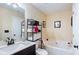 Well-lit bathroom featuring a soaking tub, vanity with marble counter and shelving unit for storage at 1501 Eastern Sunrise Ln, Decatur, GA 30034