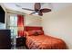 Bedroom with a ceiling fan, window, brown dresser, nightstand, an orange bed and luxury bedding at 1501 Eastern Sunrise Ln, Decatur, GA 30034