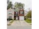 Charming two-story brick home featuring an attached garage and a beautifully manicured front yard at 1501 Eastern Sunrise Ln, Decatur, GA 30034