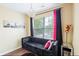 A cozy sitting area with a black sofa, throw pillows, modern mirror side table, city artwork and colorful curtains at 1501 Eastern Sunrise Ln, Decatur, GA 30034