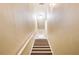 A stairway with wooden steps ascends under a light fixture, and white walls with a white banister at 1501 Eastern Sunrise Ln, Decatur, GA 30034