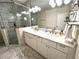 Bright bathroom featuring a double sink vanity, modern lighting, and luxurious glass shower with marble tile surround at 4002 Wieuca Ne Rd, Atlanta, GA 30342