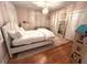 Bright bedroom featuring a white bed, hardwood floors, and decorative lighting, creating a cozy and inviting space at 4002 Wieuca Ne Rd, Atlanta, GA 30342