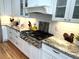 A gourmet kitchen features white cabinets, granite countertops, and a stainless steel stove cooktop at 4002 Wieuca Ne Rd, Atlanta, GA 30342