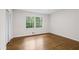 Bright bedroom features hardwood floors and a large window with green views at 5630 Lake Forrest Dr, Sandy Springs, GA 30342