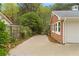 Long driveway leading to a brick home and garage, surrounded by lush greenery and mature trees at 5630 Lake Forrest Dr, Sandy Springs, GA 30342