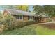 Well-maintained brick house featuring black shutters, green hedges, and a welcoming front porch at 5630 Lake Forrest Dr, Sandy Springs, GA 30342