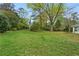 Expansive front yard featuring lush green grass and mature trees providing shade and natural beauty at 5630 Lake Forrest Dr, Sandy Springs, GA 30342