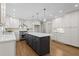 This kitchen features white cabinets, hardwood floors and a center island with gray cabinets at 5630 Lake Forrest Dr, Sandy Springs, GA 30342