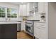 This kitchen features stainless steel appliances, white subway tile and white cabinets at 5630 Lake Forrest Dr, Sandy Springs, GA 30342