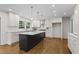 This kitchen features white cabinets, hardwood floors and a center island with gray cabinets at 5630 Lake Forrest Dr, Sandy Springs, GA 30342