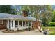 Outdoor patio area with a fire pit, surrounded by comfortable seating, flowers, and manicured landscaping at 5630 Lake Forrest Dr, Sandy Springs, GA 30342