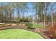 Landscaped backyard with lush lawn, mulch beds, and stone walkway at 1165 Lea Dr, Roswell, GA 30076