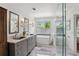 Bright bathroom with double sink vanity, soaking tub, and glass shower at 1165 Lea Dr, Roswell, GA 30076
