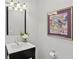 Elegant powder room featuring modern vanity, decorative mirror, and stylish artwork at 1165 Lea Dr, Roswell, GA 30076