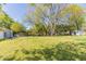 Large grassy backyard with mature trees and building in the background at 181 Bernice Dr, Lawrenceville, GA 30045