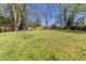 Large grassy backyard with mature trees and a small shed in the background at 181 Bernice Dr, Lawrenceville, GA 30045